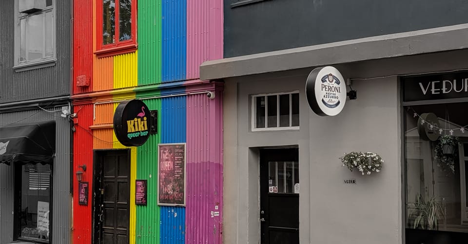 A photo of buildings in Iceland featuring a queer bar which is painted in the colors of pride.